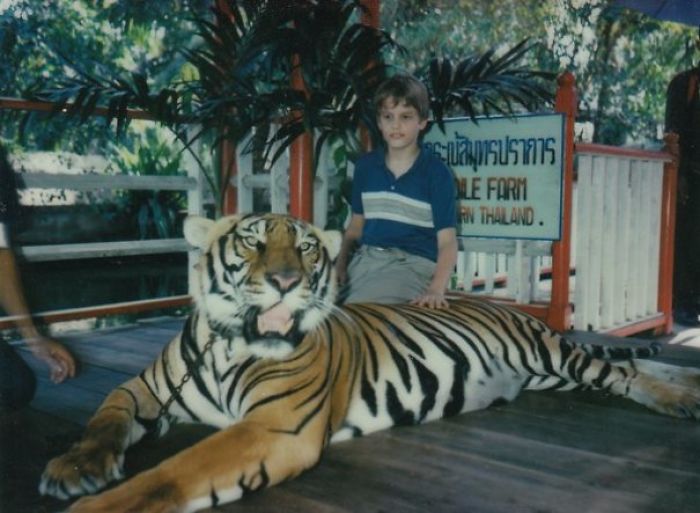 26. “Just a photo of yours truly (at 11 yrs.) petting a full-grown tiger. My mom calls it her ‘Bad Parenting Moment.'”